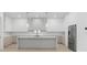 Modern kitchen with white cabinetry, stainless steel appliances, large island, and quartz countertops at 3020 W Helen Ave, Tampa, FL 33611