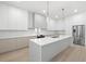 Bright, modern kitchen with stainless steel appliances, a large island, and ample cabinet space at 3020 W Helen Ave, Tampa, FL 33611