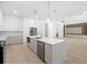 Spacious modern kitchen with an island, stainless steel appliances, and open access to the living area at 3020 W Helen Ave, Tampa, FL 33611