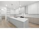 Contemporary kitchen featuring a large island, white cabinets, stylish lighting, and stainless steel appliances at 3020 W Helen Ave, Tampa, FL 33611