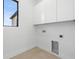Bright laundry room with upper cabinets and modern hookups at 3020 W Helen Ave, Tampa, FL 33611