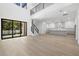 Bright open-concept living room with high ceilings, wood floors, modern staircase, and view to the kitchen at 3020 W Helen Ave, Tampa, FL 33611