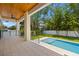 Inviting outdoor patio with a wooden ceiling, fan, railing, and a refreshing pool at 3020 W Helen Ave, Tampa, FL 33611