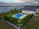 Wide aerial view of a home with a swimming pool and a view of a pond at 3409 Gulf City Rd, Ruskin, FL 33570