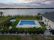 Aerial view of a backyard pool with a lake view and an umbrella table at 3409 Gulf City Rd, Ruskin, FL 33570