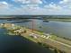 Aerial view of a home situated between two bodies of water, featuring a pool under a partly cloudy sky at 3409 Gulf City Rd, Ruskin, FL 33570
