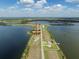 Aerial view of a home situated between two bodies of water and featuring a pool under a partly cloudy sky at 3409 Gulf City Rd, Ruskin, FL 33570