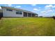 Lush backyard featuring green lawn, screened-in patio, and fence, perfect for outdoor enjoyment at 3409 Gulf City Rd, Ruskin, FL 33570