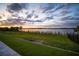 Large grassy yard with lake view at dusk at 3409 Gulf City Rd, Ruskin, FL 33570