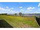 Spacious backyard with lush lawn and decorative metal fence and serene water views at 3409 Gulf City Rd, Ruskin, FL 33570