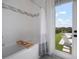Bright bathroom showcasing tub and shower with decorative tile, adjacent to the backyard entry at 3409 Gulf City Rd, Ruskin, FL 33570