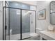 This bathroom features a glass door shower with gray tiling, a sink and vanity area, and beach themed decor at 3409 Gulf City Rd, Ruskin, FL 33570