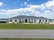 A large single Gathering home with a well-manicured lawn and beautiful landscaping under a bright partly cloudy sky at 3409 Gulf City Rd, Ruskin, FL 33570