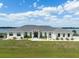 A large single Gathering home with a well-manicured lawn and beautiful front yard landscaping under a bright partly cloudy sky at 3409 Gulf City Rd, Ruskin, FL 33570