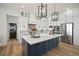Modern kitchen featuring white cabinets, a large island with countertop seating, and pendant lighting at 3409 Gulf City Rd, Ruskin, FL 33570