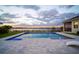 Beautiful pool with large patio, water feature, and lake view at dusk at 3409 Gulf City Rd, Ruskin, FL 33570