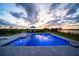 Beautiful pool with lake views, an umbrella table, two lounge chairs, and lush landscaping at 3409 Gulf City Rd, Ruskin, FL 33570