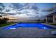 Elegant outdoor pool area with a lake view, featuring a sleek design and gray brick pavers at 3409 Gulf City Rd, Ruskin, FL 33570