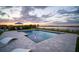 Beautiful pool with large patio, water feature, and lake view at dusk at 3409 Gulf City Rd, Ruskin, FL 33570