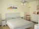 Bright bedroom featuring a ceiling fan, an art piece, and a comfortable bed with side tables and a dresser at 4179 Juniper St, Port Charlotte, FL 33948