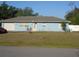 Charming light blue single story home with a well-manicured lawn and attached garage on a sunny day at 4179 Juniper St, Port Charlotte, FL 33948