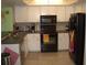 Well-lit kitchen with white cabinets, essential appliances, and tiled flooring at 4179 Juniper St, Port Charlotte, FL 33948