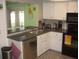 A functional kitchen with white cabinets, black appliances, and a stainless steel dishwasher at 4179 Juniper St, Port Charlotte, FL 33948