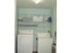 Functional laundry room with washer, dryer, and shelving for ample storage at 4179 Juniper St, Port Charlotte, FL 33948