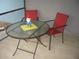 Enclosed patio with a glass table, two red chairs, and tile flooring at 4179 Juniper St, Port Charlotte, FL 33948