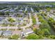 Aerial view showcases the neighborhood with canals, single Gathering homes, lush landscaping, and waterway access at 4240 Woodsville Dr, New Port Richey, FL 34652