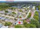Aerial view of the neighborhood with the home highlighted, showcasing its location near lush trees and a pond at 4240 Woodsville Dr, New Port Richey, FL 34652