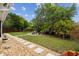 Lush backyard with stepping stones, a charming pergola, and mature landscaping for serene outdoor living at 4240 Woodsville Dr, New Port Richey, FL 34652