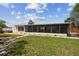 View of the screened in porch area of the backyard with the grass lawn area in the foreground at 4240 Woodsville Dr, New Port Richey, FL 34652