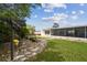 Backyard with green grass, stepping stones, tropical landscaping, a screened-in porch and a swing at 4240 Woodsville Dr, New Port Richey, FL 34652
