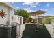 Beautiful backyard featuring green carpet, chairs, and an umbrella for outdoor enjoyment at 4240 Woodsville Dr, New Port Richey, FL 34652