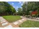 Landscaped backyard with stepping stones, green lawn, and multiple seating areas at 4240 Woodsville Dr, New Port Richey, FL 34652