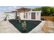 Open backyard featuring a green carpet, potted plants and a sun design at 4240 Woodsville Dr, New Port Richey, FL 34652