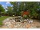 Beautiful backyard with a small waterfall, seating area, and mature landscaping at 4240 Woodsville Dr, New Port Richey, FL 34652