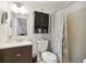 Well-lit bathroom featuring a toilet, vanity with dark wood cabinets, and a shower with a patterned curtain at 4240 Woodsville Dr, New Port Richey, FL 34652