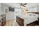 Bright bedroom with a wooden bed frame, a ceiling fan, and a large window with blinds at 4240 Woodsville Dr, New Port Richey, FL 34652