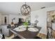 Open-concept dining room with a modern light fixture, and a view of the living room at 4240 Woodsville Dr, New Port Richey, FL 34652