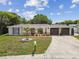 Charming single-story home with an arched entryway, and a well-manicured lawn at 4240 Woodsville Dr, New Port Richey, FL 34652