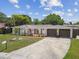 Charming single-story home featuring an arched entryway, a well-manicured lawn, and an attached two-car garage at 4240 Woodsville Dr, New Port Richey, FL 34652