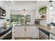 Well-lit kitchen showcasing granite countertops, white cabinets, stainless appliances, and a garden view at 4240 Woodsville Dr, New Port Richey, FL 34652