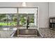 Close-up of kitchen sink with view to screened outdoor living space and landscaped backyard at 4240 Woodsville Dr, New Port Richey, FL 34652