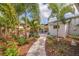 Beautifully landscaped backyard with stone path, pergola, seating, and vibrant plants, perfect for outdoor living at 477 44Th N Ave, St Petersburg, FL 33703