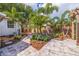 Lush backyard featuring vibrant plants, palm trees, a pergola, and a paved patio at 477 44Th N Ave, St Petersburg, FL 33703