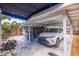 Covered carport with a parked car, a storage shed, and access to a beautifully landscaped backyard at 477 44Th N Ave, St Petersburg, FL 33703