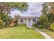 Charming home featuring a lush green lawn, inviting walkway, and beautiful, mature landscaping at 477 44Th N Ave, St Petersburg, FL 33703