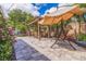 Charming backyard patio with pergola, dining set, and relaxing swing, surrounded by lush greenery at 477 44Th N Ave, St Petersburg, FL 33703